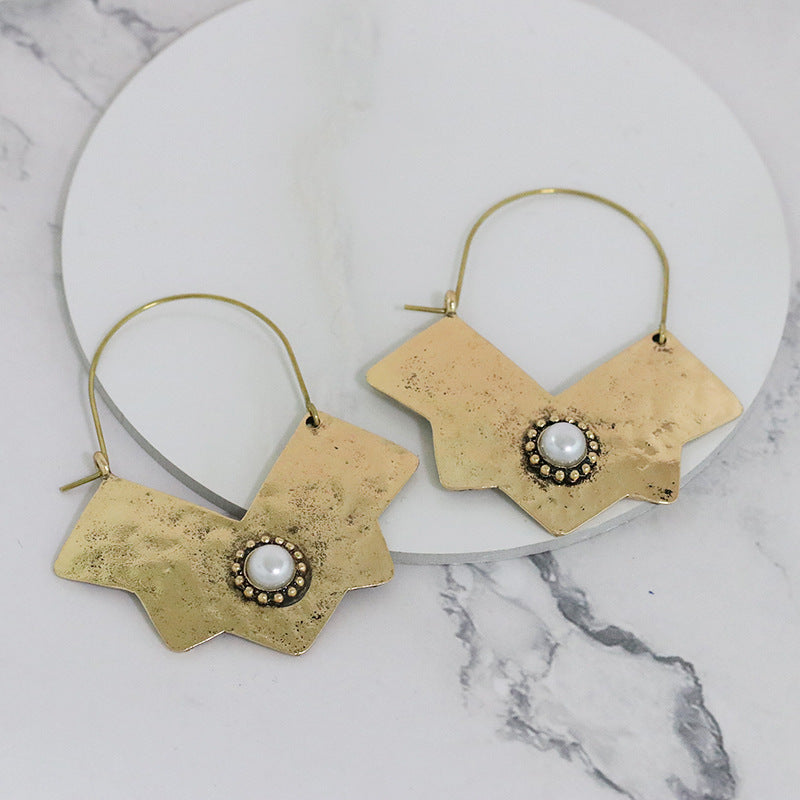 Gyllene örhängen med pärlglans i mitten och skarpa linjer - mystiskt och unikt!