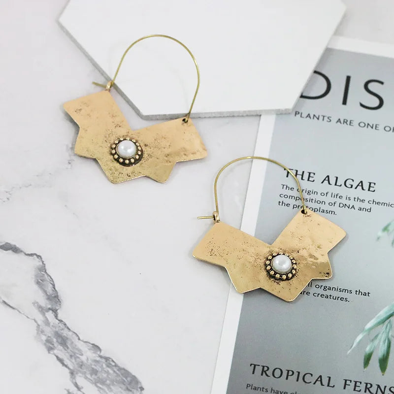 Gyllene örhängen med pärlglans i mitten och skarpa linjer - mystiskt och unikt!